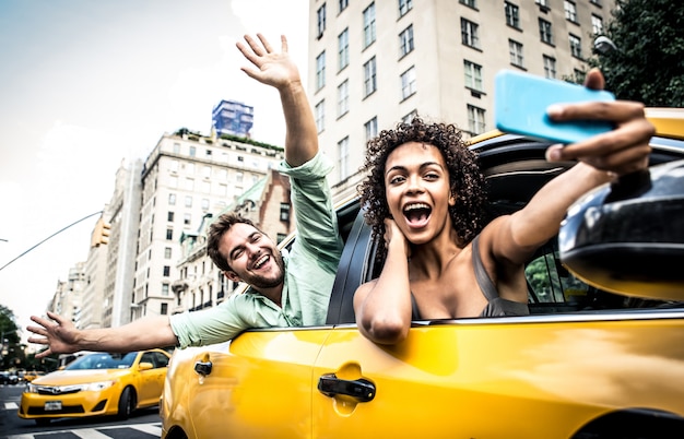 Pareja feliz en un taxi amarillo en Nueva york