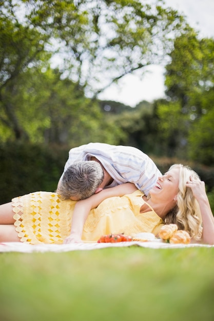 Pareja feliz teniendo un picnic fuera