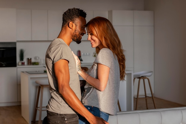 Pareja feliz de tiro medio en casa