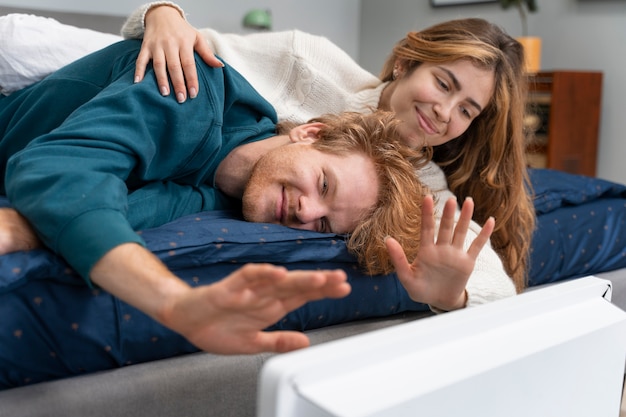 Pareja feliz de tiro medio cerca del calentador