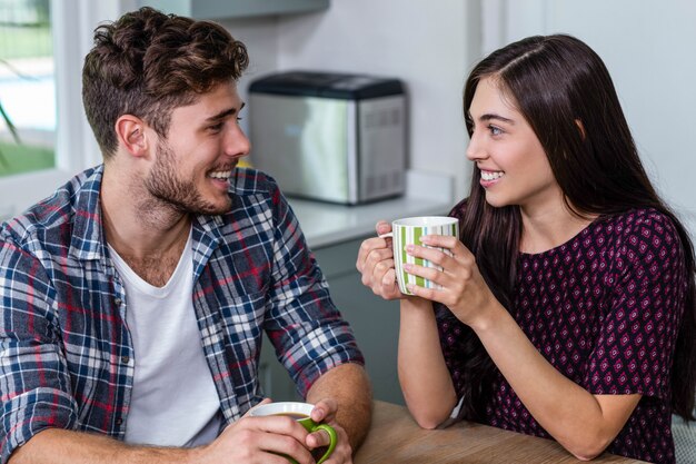 Pareja feliz tomando café juntos en casa