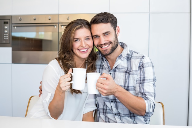 Pareja feliz tomando café por mesa