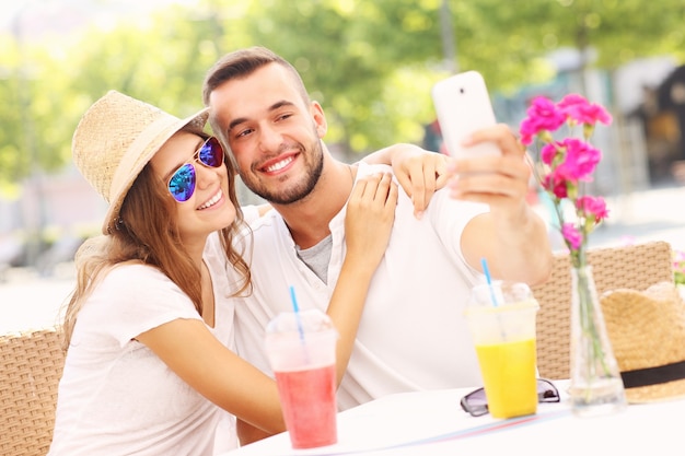 una pareja feliz tomando selfie en un café