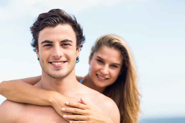 Pareja feliz en traje de baño mirando a cámara y abrazando