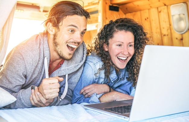 Foto una pareja feliz usando una computadora portátil en una caravana