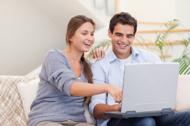 Pareja feliz usando una computadora portátil