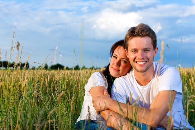 Pareja feliz en verano en la hierba de un prado