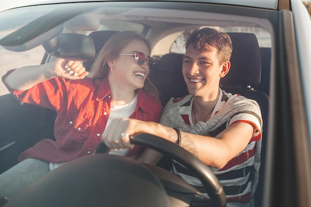 Pareja feliz viajando juntos. Hombre y mujer divirtiéndose en el viaje. Coche compartido para jóvenes.