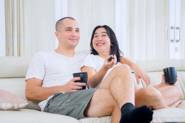 Pareja feliz viendo la televisión juntos en casa