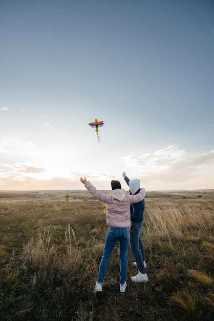 Una pareja feliz vuela una cometa y pasa tiempo juntos al aire libre. Feliz relación y vacaciones familiares.