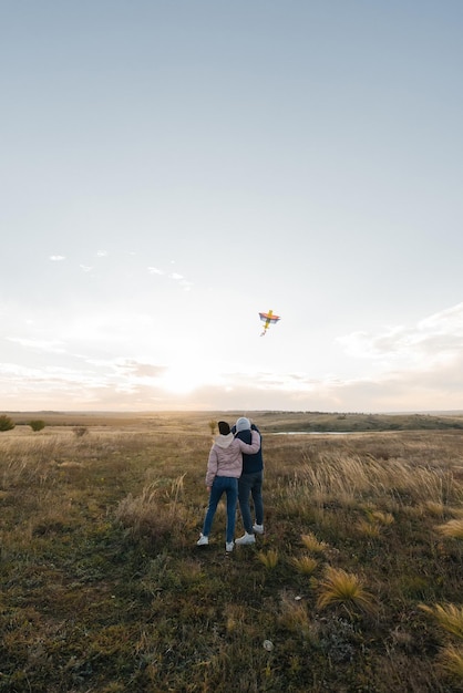 Una pareja feliz vuela una cometa y pasa tiempo juntos al aire libre en una reserva natural Relaciones felices y vacaciones familiares Libertad y espacio