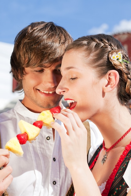 pareja en la feria bávara comiendo dulces