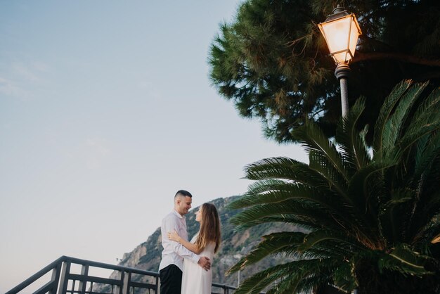 Una pareja frente a un poste de luz con una luz encendida