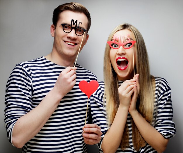 Pareja con gafas de fiesta y sombrero en palos