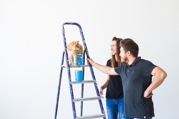 Pareja con gato haciendo una renovación en apartamento nuevo.