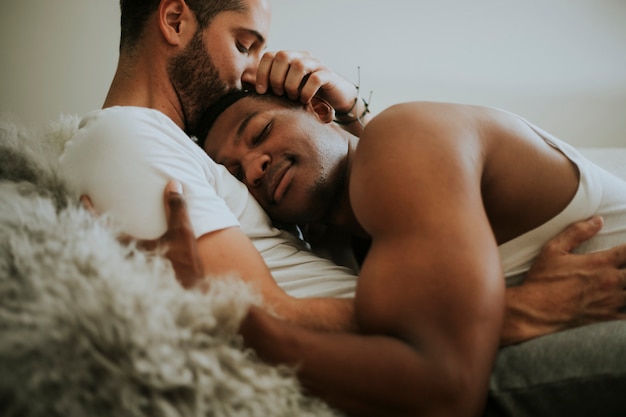 Pareja gay abrazándose en la cama