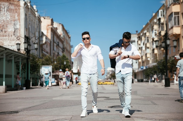 Una pareja gay asiática camina por la calle mirando los lugares de interés y pasándose un buen rato juntos Bien vestidos a la moda