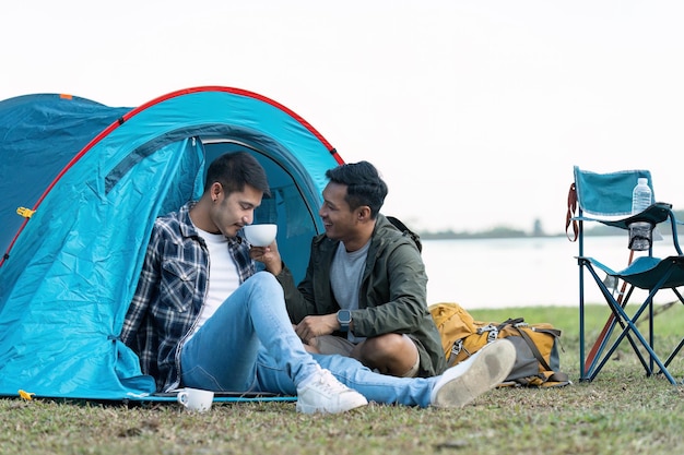 Una pareja gay asiática feliz acampando juntos en un bosque. Viaje romántico de vocación. Concepto LGBT.