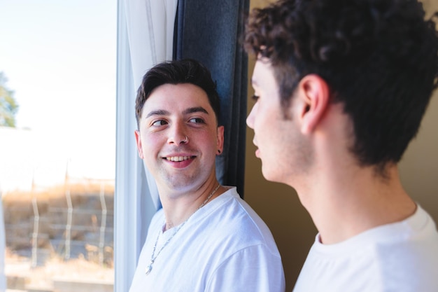 Pareja gay compartiendo un momento especial en la mañana junto a la ventana Ternura romántica homosexual