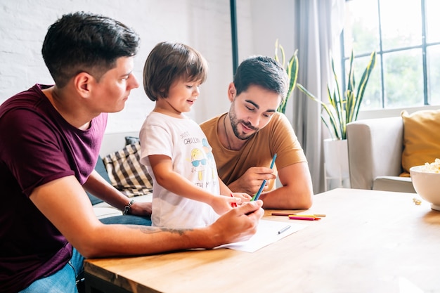 Pareja gay divirtiéndose con su hijo en casa.