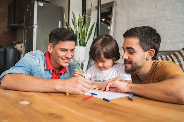 Pareja gay divirtiéndose con su hijo en casa.