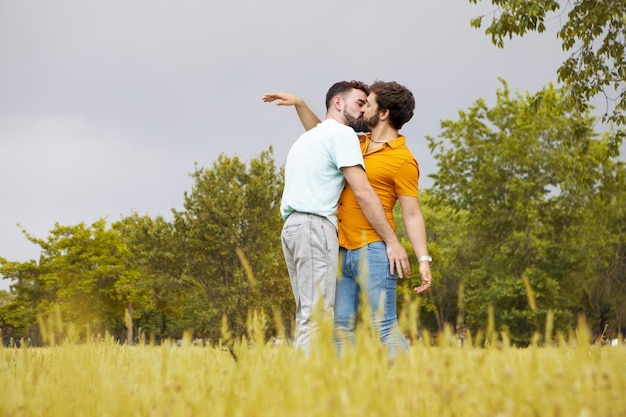 Pareja gay en el parque Joven abrazando y besando a su novio