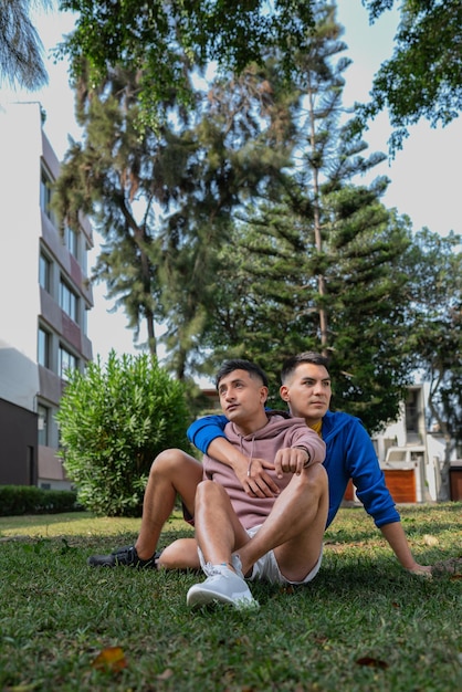 Una pareja gay sentada distraída en un parque