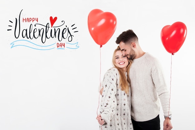 Pareja con globos de corazón en el día de San Valentín