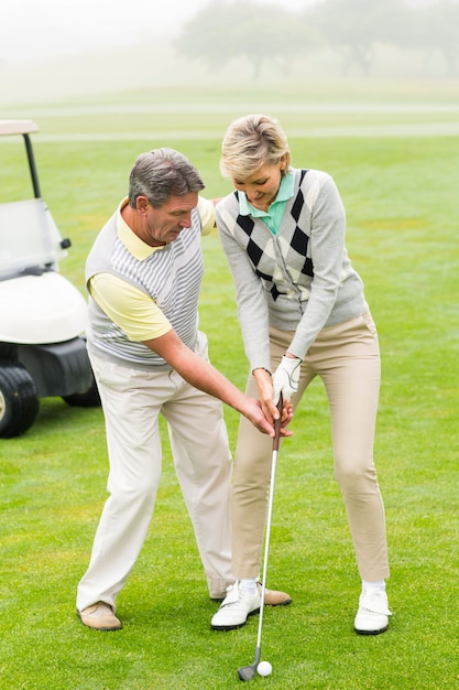 Pareja de golf poniendo la bola juntos