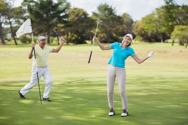 Pareja de golfistas celebrando el éxito