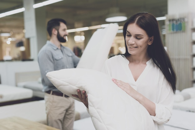 Pareja en una gran tienda de almohadas elige.