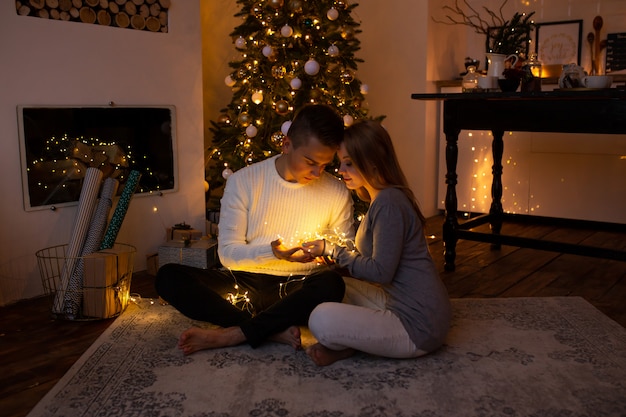 Pareja con guirnalda de luz mágica en manos