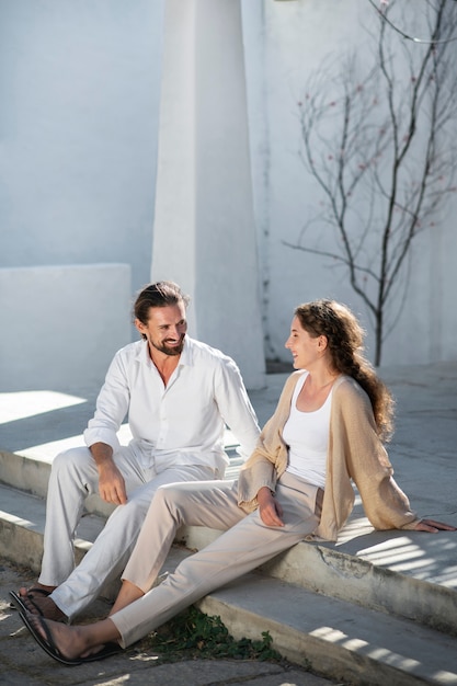 Pareja hablando y sentada afuera durante las vacaciones