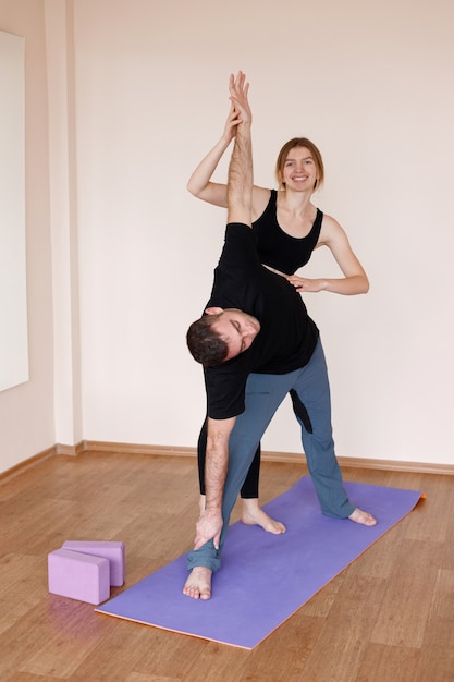 Pareja hace yoga en grupo de yoga