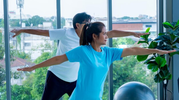 Una pareja haciendo ejercicio junto a la ventana.