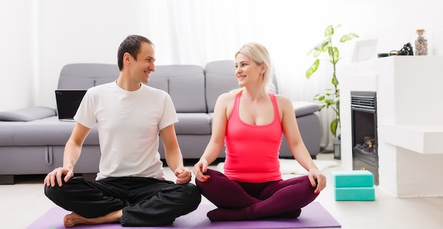 pareja haciendo ejercicios en casa. Concepto de yoga.