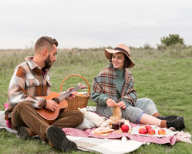 Foto pareja haciendo un picnic en la naturaleza