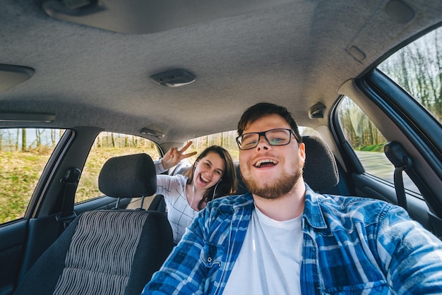 Pareja haciendo selfie en coche concepto de viaje en coche