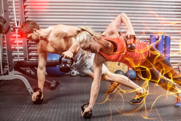 Foto pareja haciendo subir con pesas en el gimnasio de crossfit