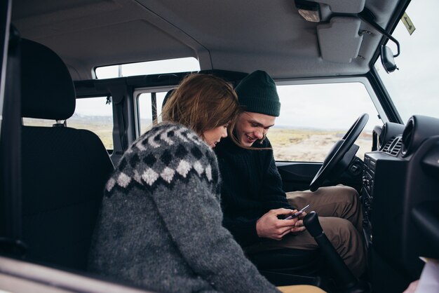 Pareja haciendo unas vacaciones de pasión por los viajes, explorando Islandia con su jeep 4x4