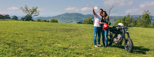 Pareja haciéndose un selfie con una moto