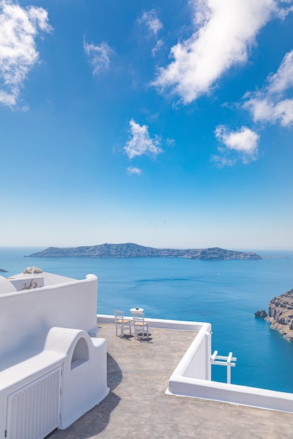 Pareja hermosa escena de viaje dos sillas blancas en la caldera, vacaciones románticas en la isla de Santorini, Grecia