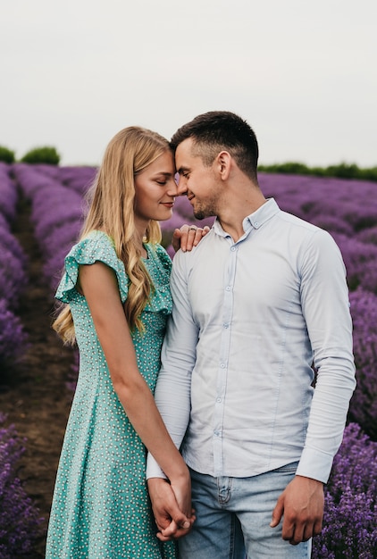 Una pareja hermosa y feliz en el campo de lavanda