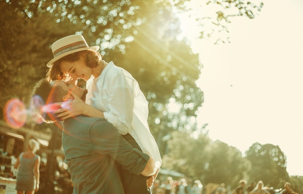 Pareja de hipster alegre alegre enamorado besándose en una calle de la ciudad