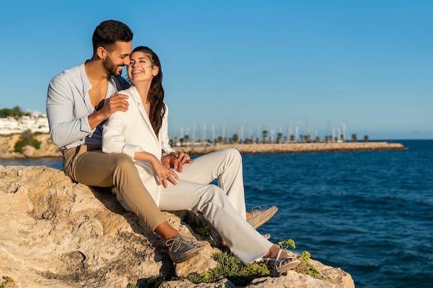 Pareja hispana, enamorado, en, rocas, en, playa