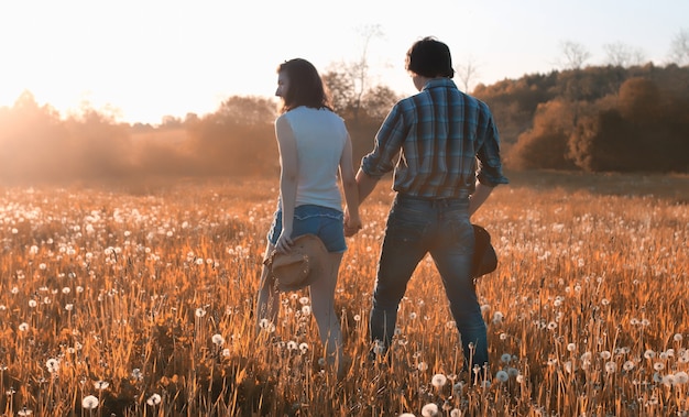 Pareja de un hombre joven y una niña están caminando en el parque de otoño