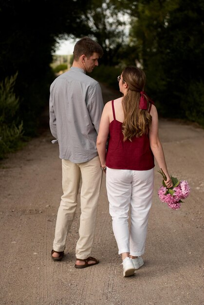 una pareja de hombre y mujer. amantes un chico y una chica están caminando. niña con flores