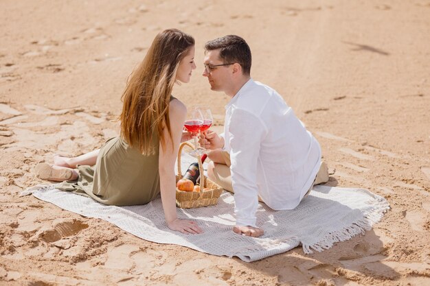 Una pareja de un hombre y una mujer caminan por la playa y hacen un picnic en la arena de