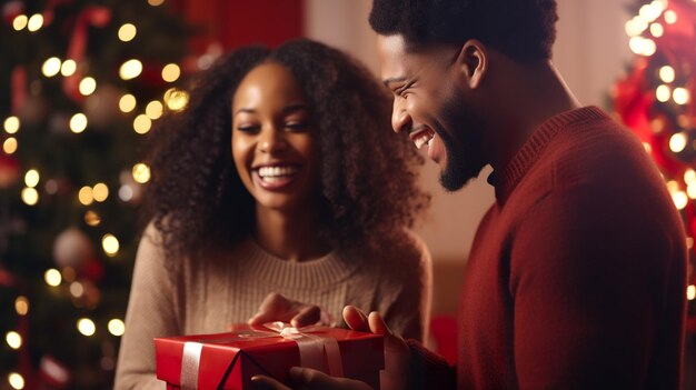 Foto una pareja de hombres y mujeres afroamericanos sonrientes y lindos sosteniendo una caja de regalos roja en la sala de estar para navidad