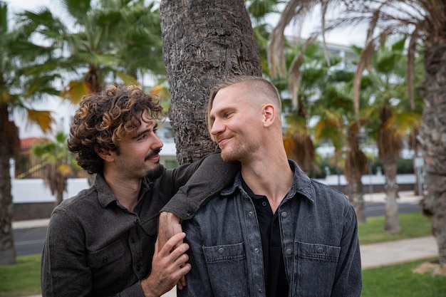 Pareja homosexual, los socios se miran, dos chicos están enamorados y celebran su amor. Relación homosexual. Chicos afuera en un parque.